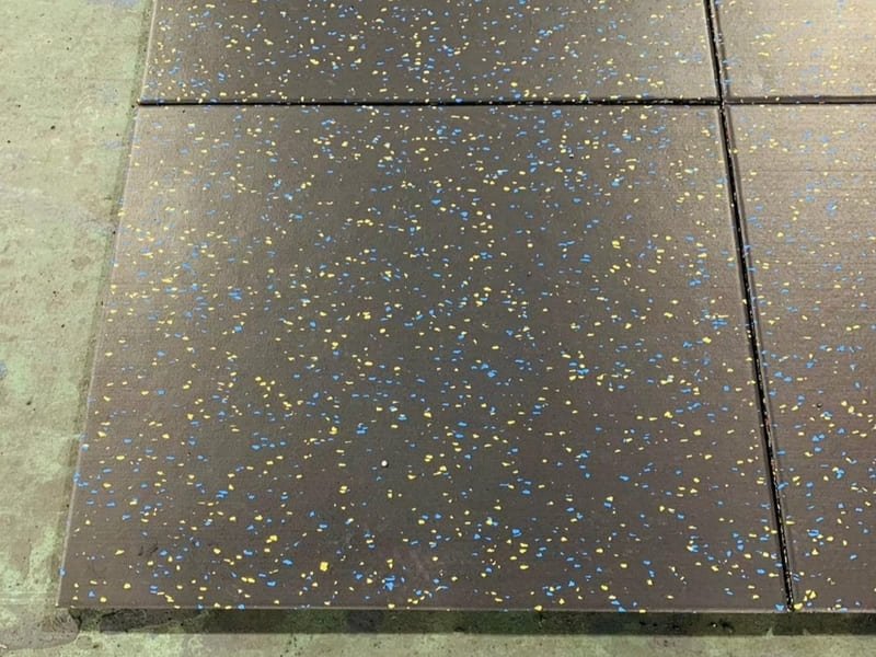 A gym owner comparing a physical flooring sample to a Pantone color swatch under the gym's actual lighting.